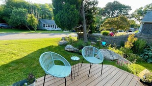 A wooden deck with two wicker chairs and a small table. - West Island Getaway - Unique 2 Bedroom Cottage (Fairhaven)