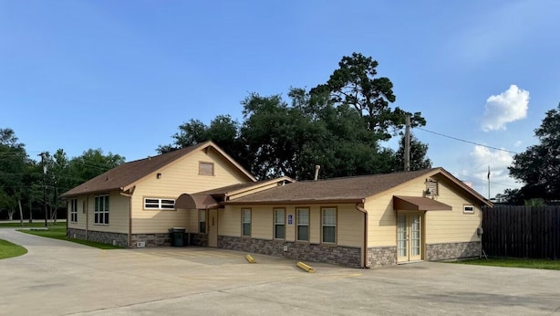 A two-story building with a garage, a covered porch, and a driveway. - Executive Living 4BR 2BA in Beaumont (Beaumont)