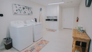 A laundry area with two washing machines, a sink, and a small cabinet. - Executive Living 4BR 2BA in Beaumont (Beaumont)