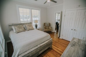 A bedroom with a bed, a chair, and a door. - Executive Living 4BR 2BA in Beaumont (Beaumont)