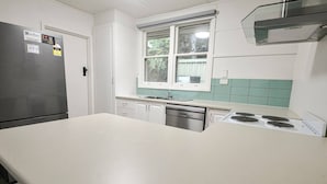 Keittiössä on jääkaappi, astianpesukone, liesi ja ikkuna, josta on näkymä.