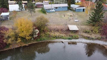 A residential area with a pond, houses, and trees.