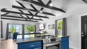 A modern kitchen with a central island, built-in oven, and blue cabinetry. - Table Rock Lakefront Studio w Access_Private Hot Tub_Free Daily Tickets (Hollister)