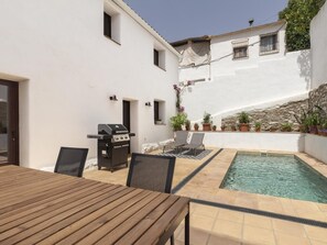 A patio with a pool, a grill, and outdoor seating. - Rustic house with a swimming pool in Nigüelas (Nigüelas)