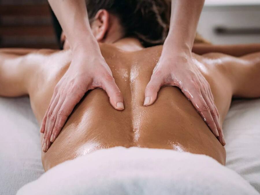 Une personne qui reçoit un massage du dos sur un lit.