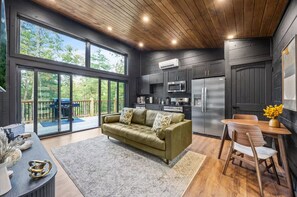 A modern kitchen with dark cabinetry, a built-in microwave, and a refrigerator. - Couples Retreat–2 Private Cabins,Hot Tubs,Firepits (Sevierville)