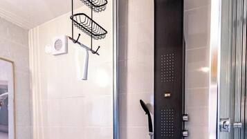 Une salle de bain moderne avec une douche à parois de verre, des toilettes, un lavabo et un porte-serviettes.
