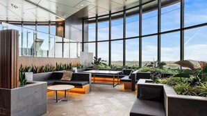 Un interior moderno con ventanas amplias, una zona de estar y vistas a la ciudad.