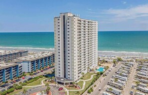 A high-rise hotel with multiple floors, a parking lot, and a beach view. - Ocean View 2BR Retreat-Renaissance Tower 1616 (Myrtle Beach)