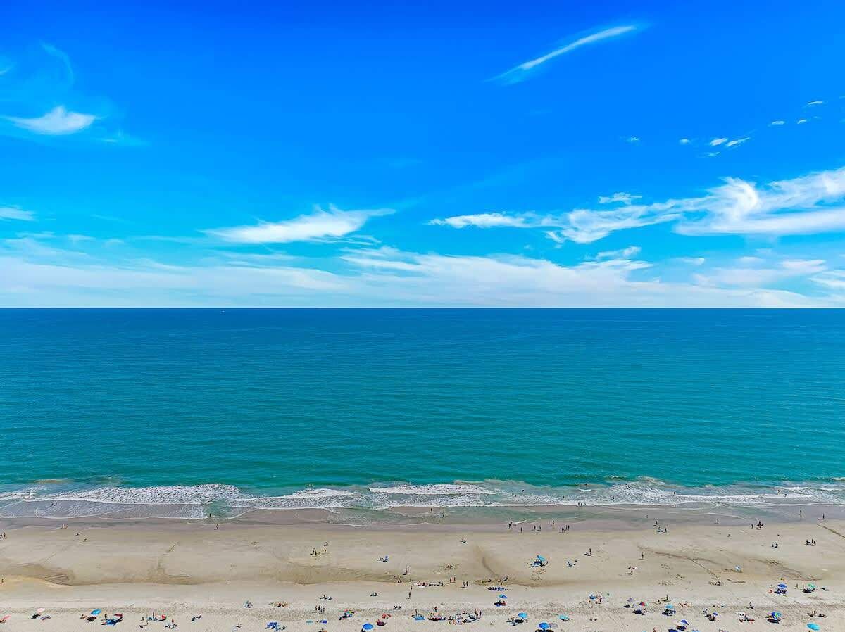 A beach with a clear sky and calm sea.