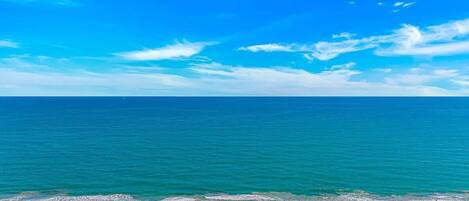 A beach with a clear sky and calm sea.