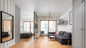 Uma sala de estar moderna com sofá, uma mesinha, um espelho e um guarda-roupa.