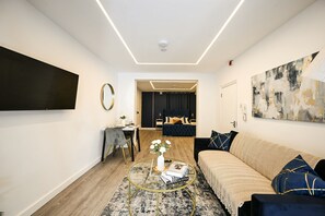 A modern living room with a sofa, coffee table, and artwork on the walls. - Islington Garden Studio, Sleeps 4, Pet-Friendly! (Greater London)