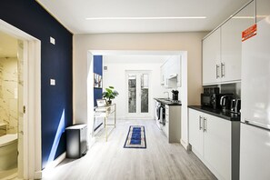 A modern kitchen with white cabinets, a black countertop, and a built-in oven. - Islington studio, ideal for professionals! (Greater London)