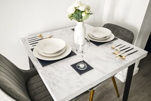 A dining table set with plates, cutlery, and a glass of water. - Islington Garden Studio, Sleeps 4, Pet-Friendly! (Greater London)