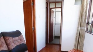 Una habitación con sofá, mesa de vidrio y suelo de madera.