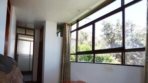 Una habitación con un ventanal grande, una mesa roja y un sofá.