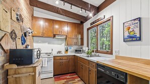 Una cocina con armarios de madera, microondas, tostadora y lavavajillas.