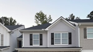 Een tweelaags huis met garage, een gevel van baksteen en een oprit.