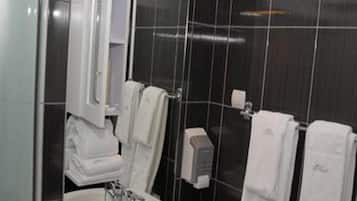 Ein Badezimmer mit Waschbecken, Spiegel, Handtuchhalter und Seifenspender.