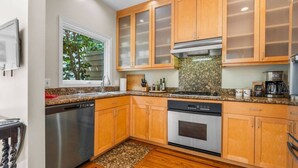 A modern kitchen with wooden cabinets, stainless steel appliances, and a granite countertop. - SF Presidio Heights Haven + Steps 2 Presidio Park (San Francisco)