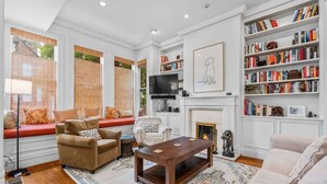 A living room with a fireplace, bookshelves, and a television. - SF Presidio Heights Haven + Steps 2 Presidio Park (San Francisco)
