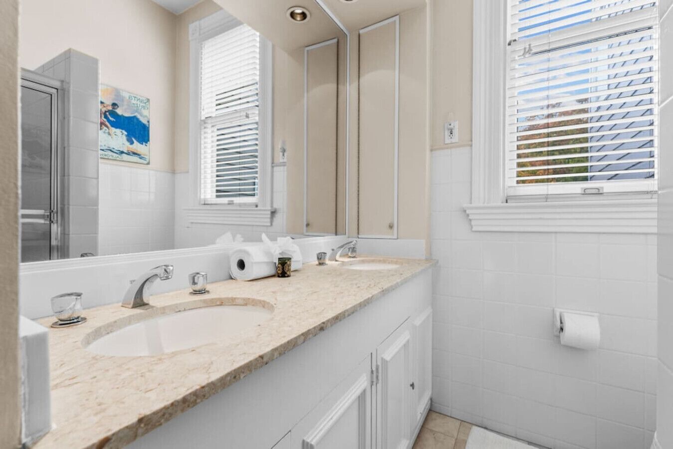 A bathroom with a large sink, a mirror, and a window with blinds.