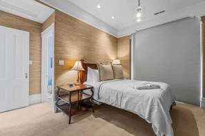 A bedroom with a bed, bedside table, lamp, and a window with blinds. - SF Presidio Heights Haven + Steps 2 Presidio Park (San Francisco)