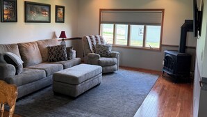 A living room with a sofa, ottoman, and a fireplace.