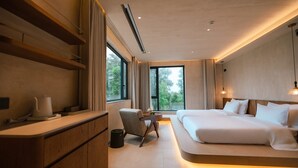 Un dormitorio moderno con una cama grande, un escritorio y una silla.