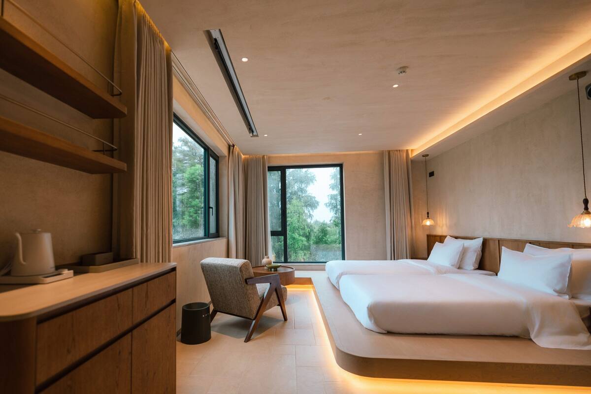 Un dormitorio moderno con una cama grande, un escritorio y una silla.