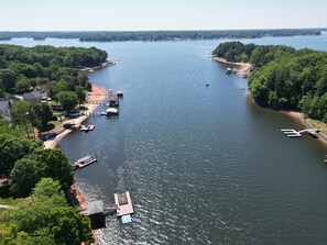 Un río con muelles y barcos, rodeado de vegetación y casas.