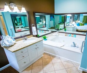 Un baño con lavamanos, espejo, bañera y un perchero para toallas.
