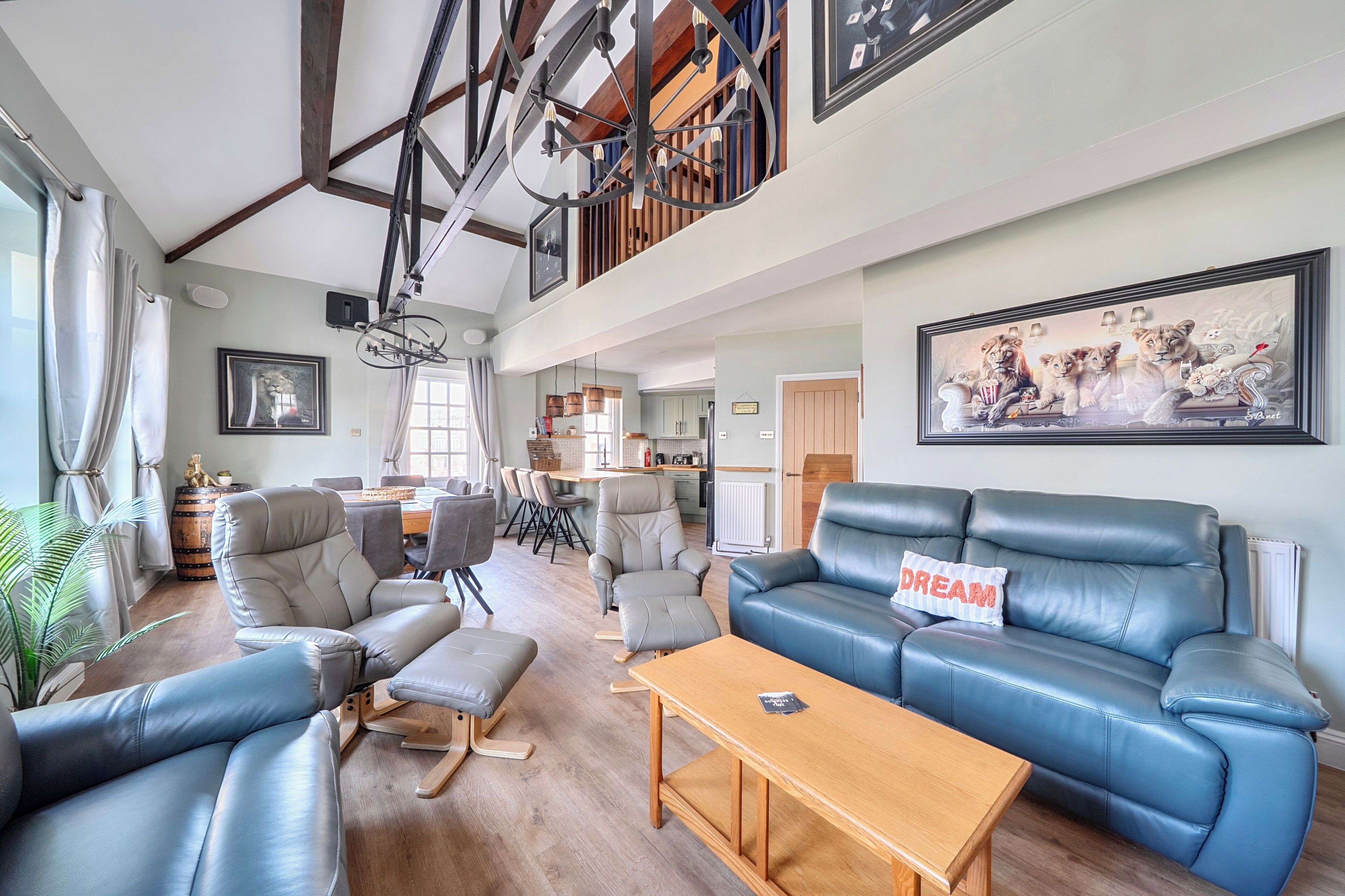 A spacious living area with a high ceiling, a dining area, and a kitchen.