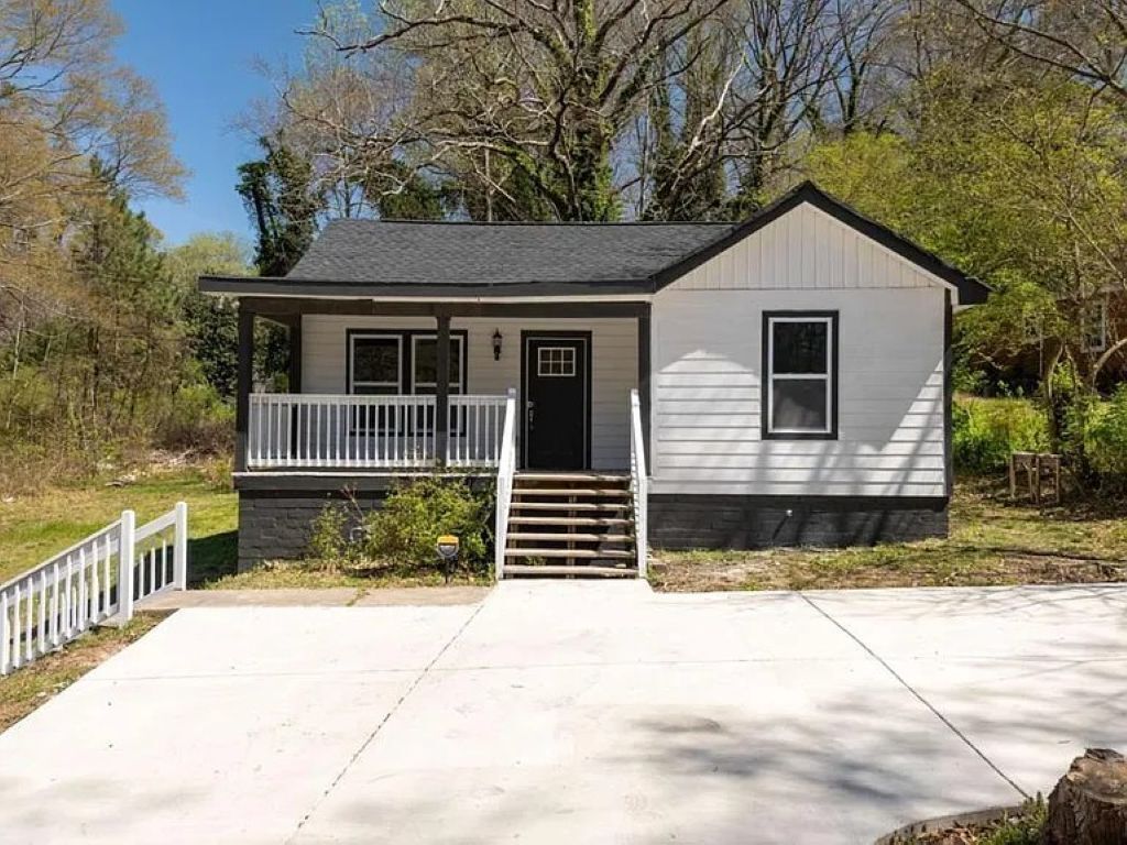 A single-story house with a front porch, a small staircase leading to the door, and a front yard.