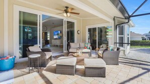 An outdoor patio area with wicker furniture, a ceiling fan, and a view of the interior. - 3BR 3BA House - Pool & Spa - Beach Access Included (Marco Island)