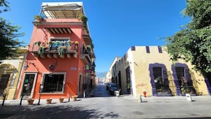 Una calle con edificios, un hidrante y un cielo azul despejado.