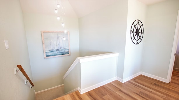 A staircase with a wooden handrail, a painting of a sailboat, and a compass wall decoration. - Soundside, Ocean views, Private Pool, Comm Amenities-  MS826, Ciao Bella (Corolla)