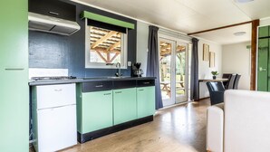 A modern kitchen with a gas stove, a coffee maker, and a view of the outdoors through a sliding glass door. - 2 bedroom gorgeous home in Erm (Erm)