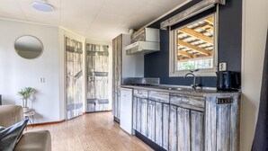 Una cucina con mobili in legno, piano cottura integrato e finestra vista sulla struttura del tetto.