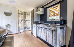 Eine K üche mit Holzausstattung, einem eingebauten Herd und einem Fenster mit Blick auf die Dachkonstruktion.