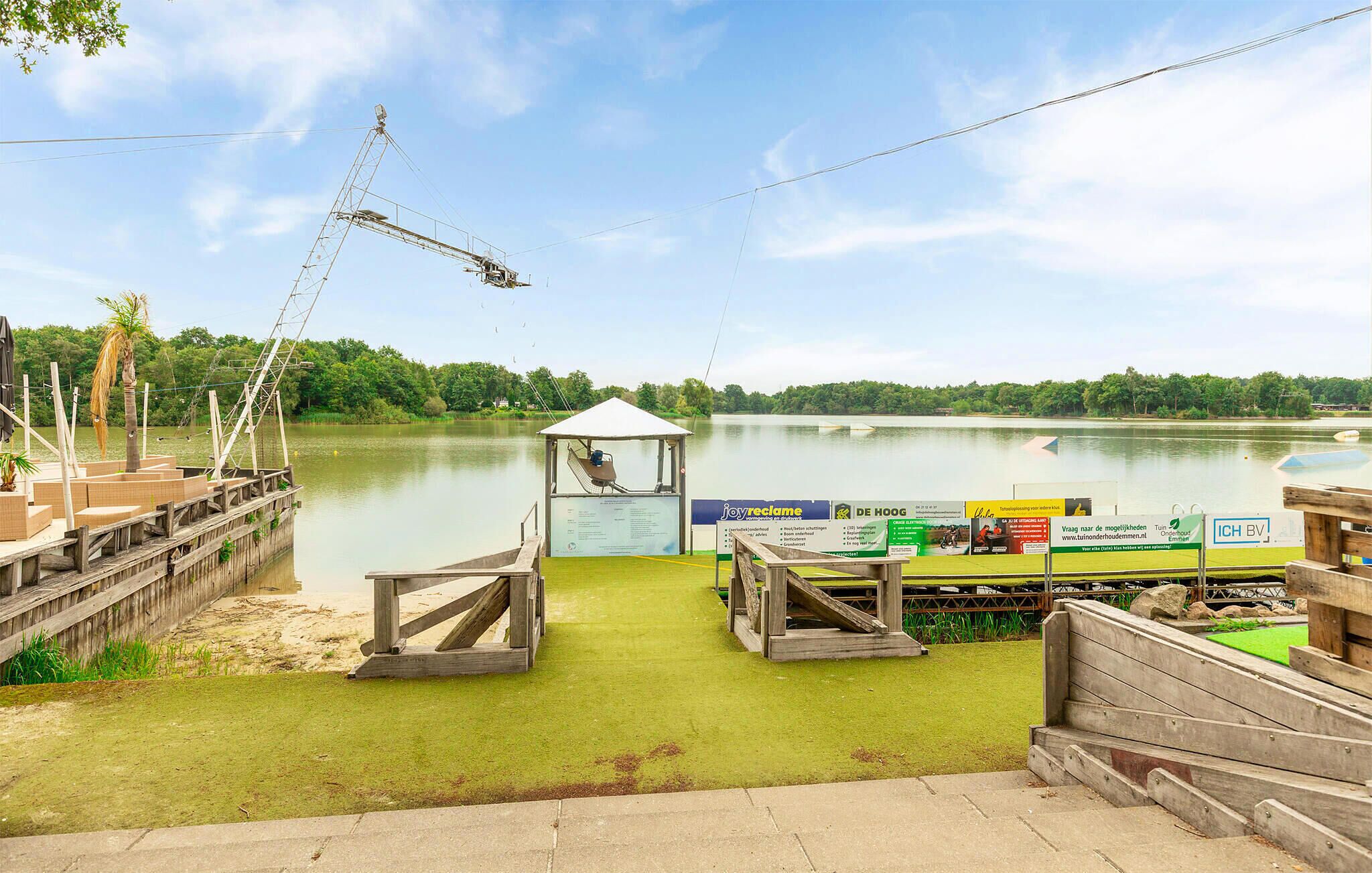 A lakeside dock with a small pavilion, a fishing boat, and a crane.