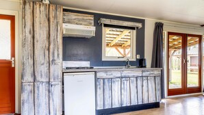 Una cucina con lavastoviglie integrata, una finestra vista sul tetto e una porta scorrevole in vetro che dà su uno spazio all'aperto.