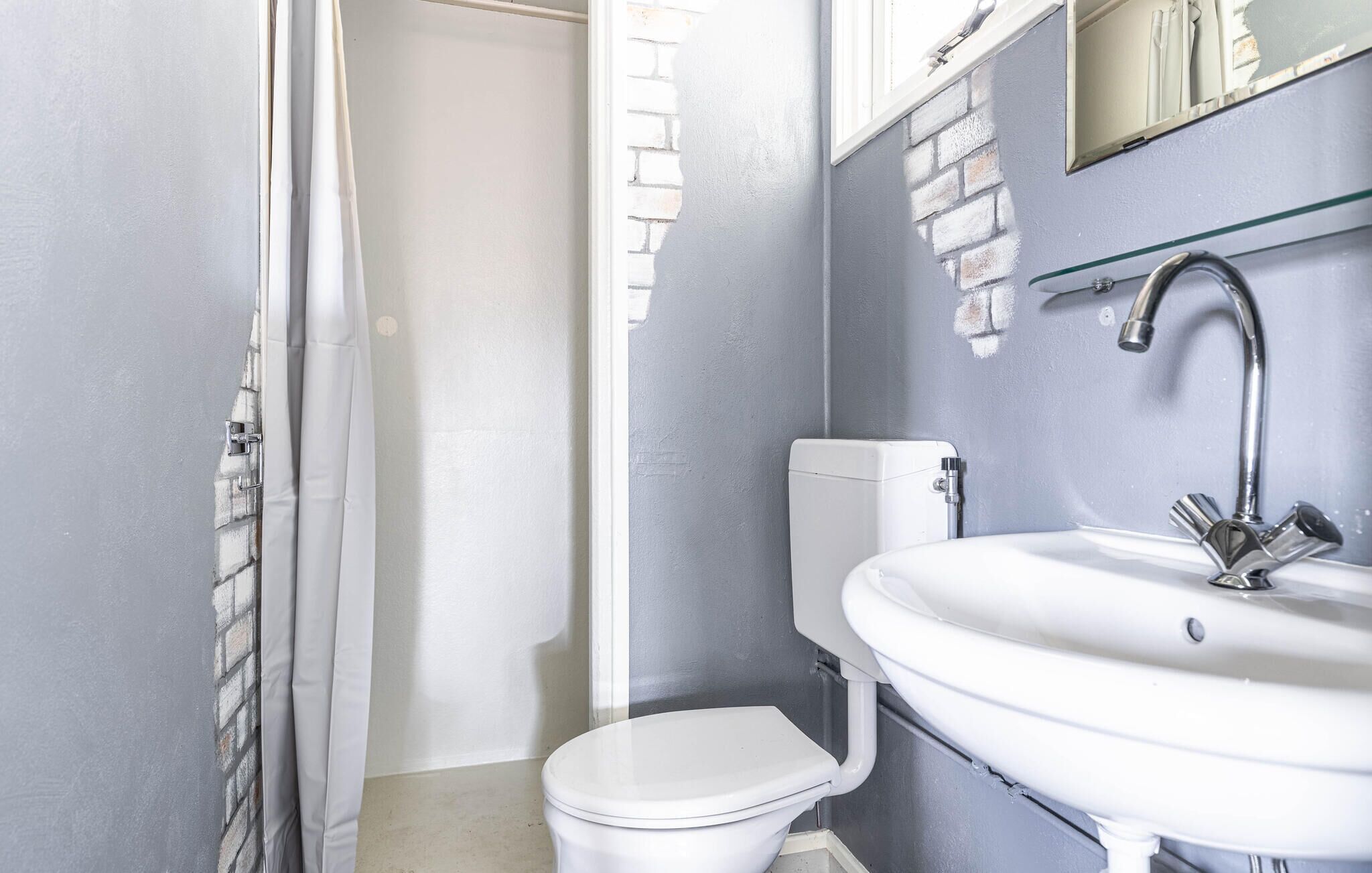 Un baño con inodoro, lavabo y cortina de ducha.
