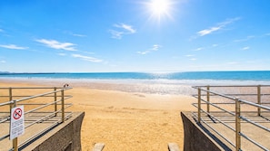 A beach with a metal railing and a sign indicating no dogs allowed. - Meridian Bay - 1 Bedroom Apt - Swansea (Swansea)