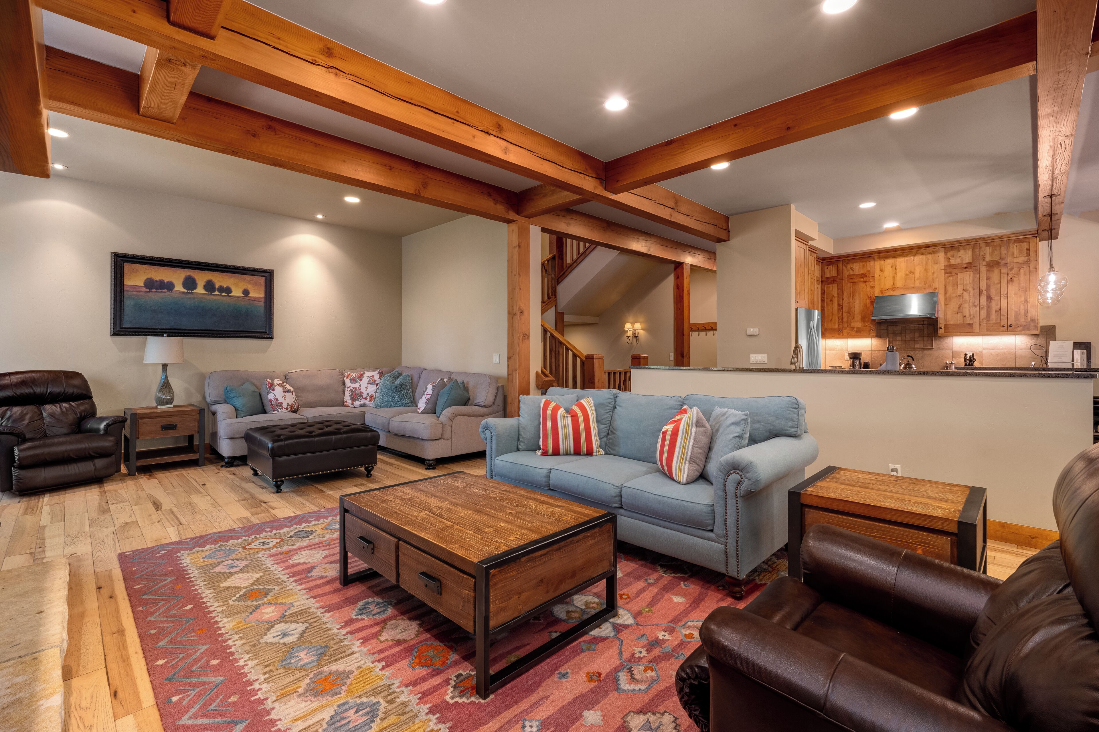 A spacious living room with a fireplace, a dining area, and a kitchen with wooden cabinets.