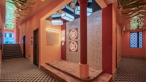 A hallway with patterned carpet, a staircase, and a wall with illuminated text. - Boni Hotel Guangzhou Huangsha Station (Guangzhou)