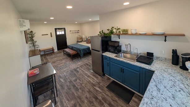 A compact kitchen with a refrigerator, sink, and countertop.