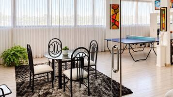 Game room with board game & card table, ping pong and view of the city