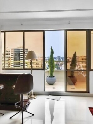 A modern room with large windows, a potted plant, and a chair.